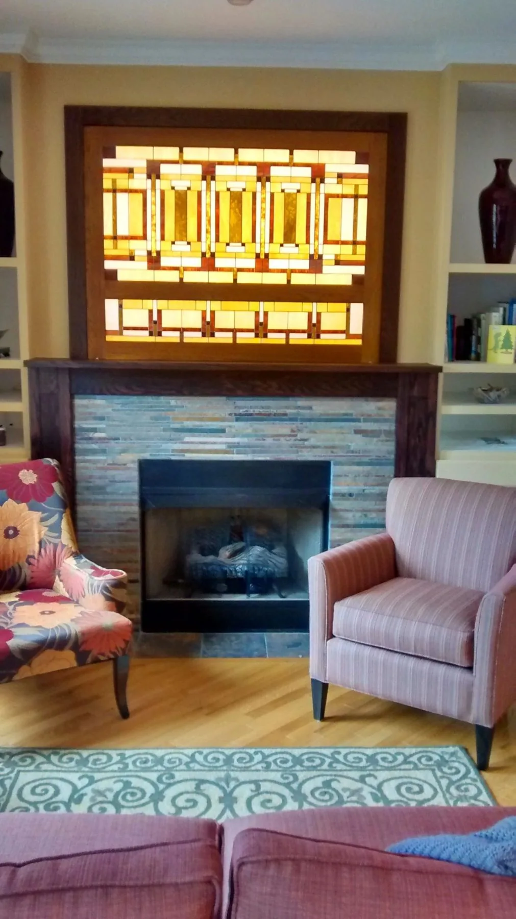 A custom fireplace surround with stained glass above the mantle