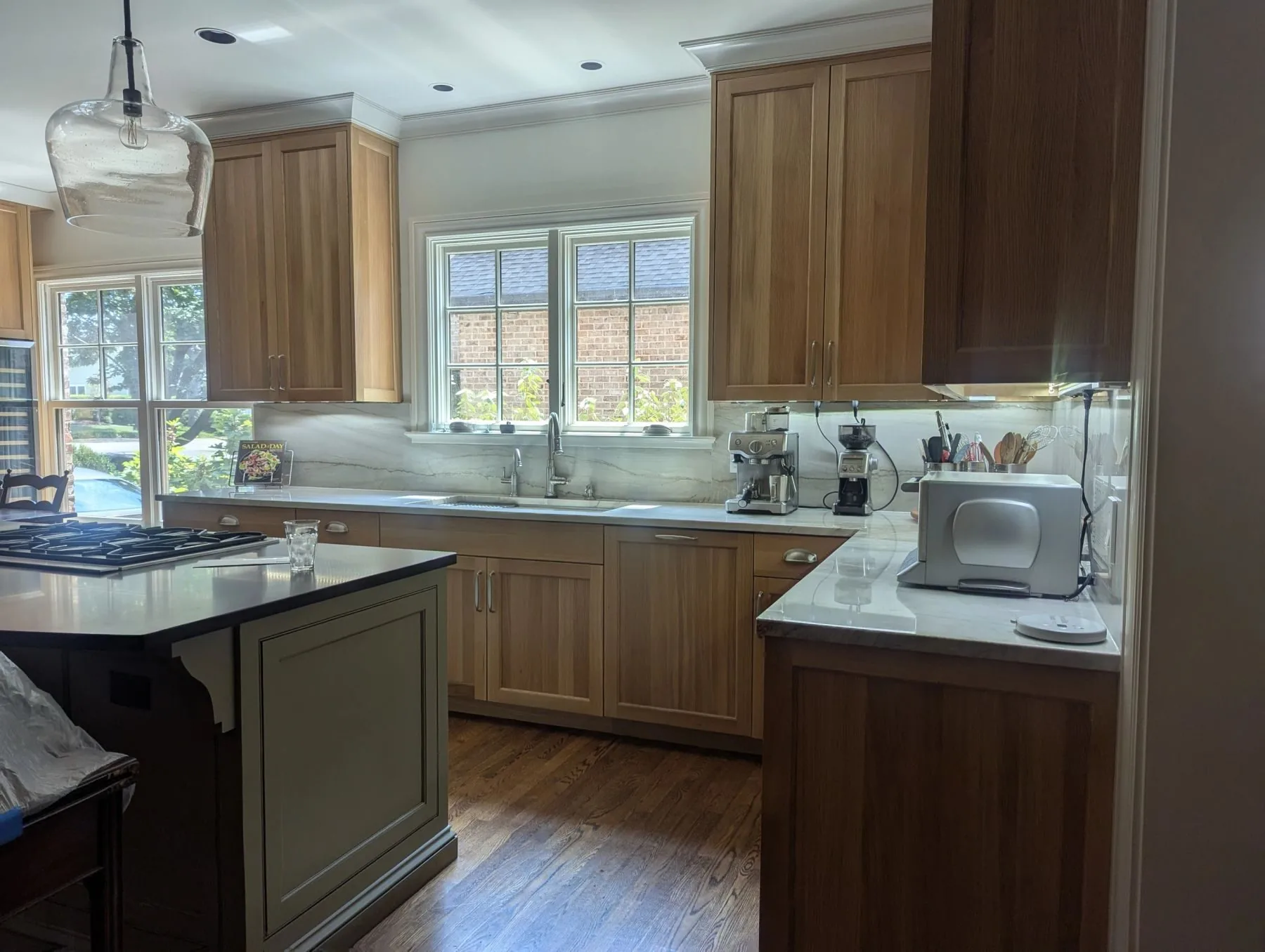 A full custom kitchen in white oak with a dark island